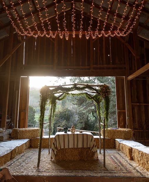 Barn interior with string lights and arch