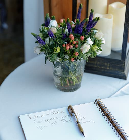 Floral arrangement and guest book on table