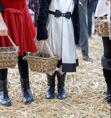 Guests in boots on hay-covered ground